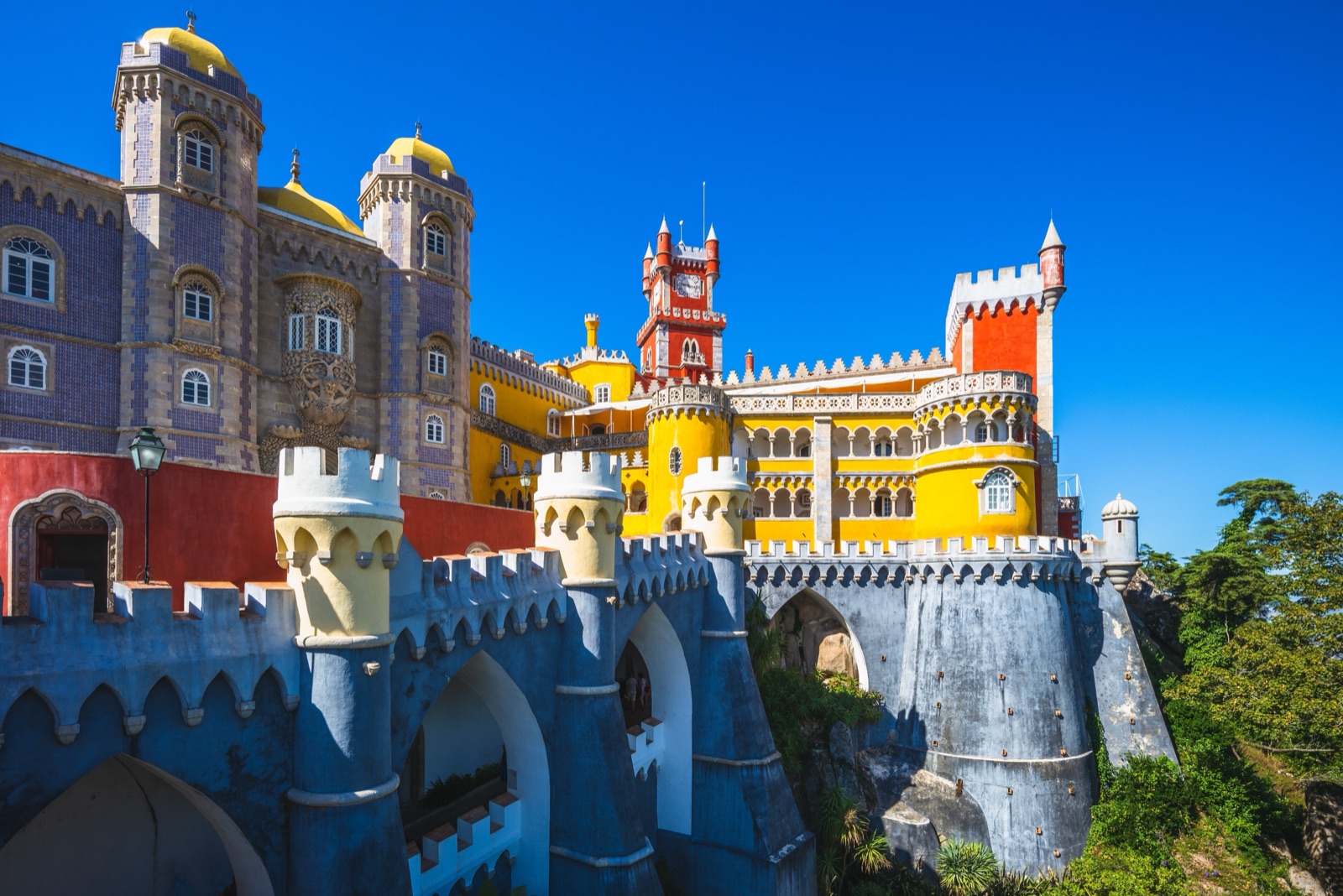 Pena Palace's yellow and red towers and terraces under a blue sky